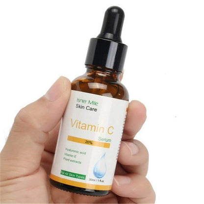 Hand hält eine Flasche Isner Mile Vitamin C Serum mit Pipette.